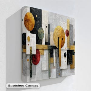 Op de afbeelding: Abstracte geometrische canvas kunst met gouden, zwarte, witte en rode vormen. Het kunstwerk bevat cirkels en rechthoekige vormen met een getextureerd oppervlak. De woorden "Stretched Canvas" zijn onderaan zichtbaar.