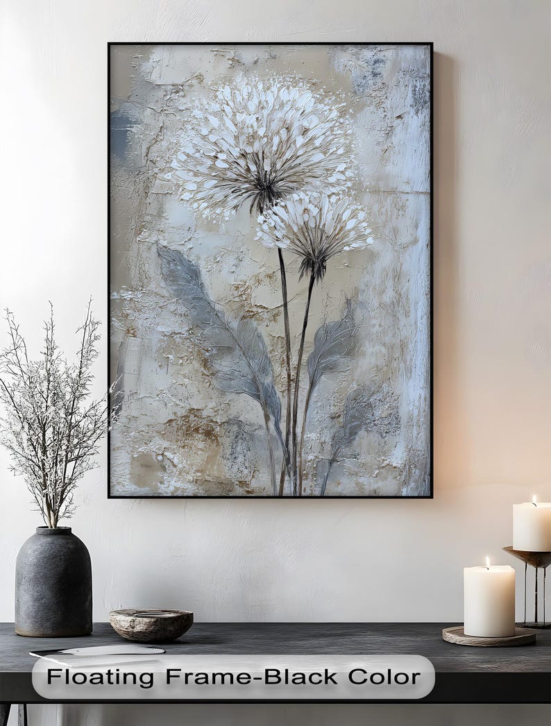 a floating frame-black color painting of a dandelion flower on a wall, with a black shelf below it and a vase with branches and a candle on the shelf.