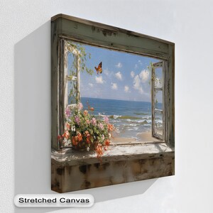 Könnte beinhalten: Ein Kunstdruck auf Leinwand, der eine Küstenlandschaft durch ein Fenster zeigt. Das Kunstwerk zeigt einen Schmetterling, Blumen und einen blauen Himmel. Der Text "Stretched Canvas" befindet sich unten. Der Fensterrahmen hat ein verwittertes Aussehen.