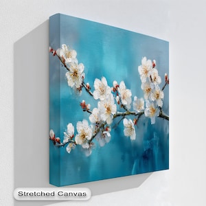 May include: A stretched canvas art print featuring a branch of white blossoms against a teal blue background. The flowers have yellow centers and red buds. The words "Stretched Canvas" are at the bottom.