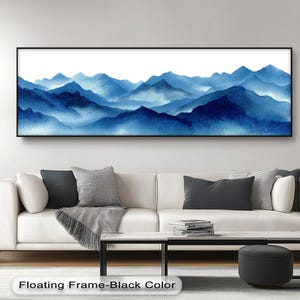 Könnte beinhalten: Gerahmtes Aquarellgemälde eines blauen Bergmassivs. Das Kunstwerk zeigt eine Panoramaansicht von geschichteten Gipfeln vor weißem Hintergrund. Der Rahmen ist schwarz. Der Text unten lautet "Floating Frame-Black Color."