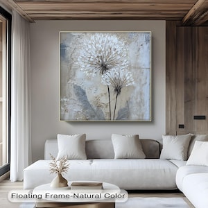 a modern living room with a large abstract painting of white flowers hanging on the wall above a white sofa.