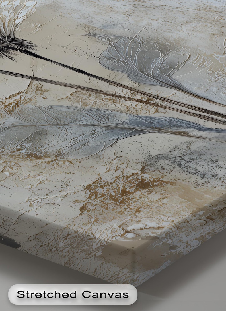 A close-up view of a stretched canvas with a textured, abstract design featuring a mix of light and dark colors, including shades of gray, brown, and beige.