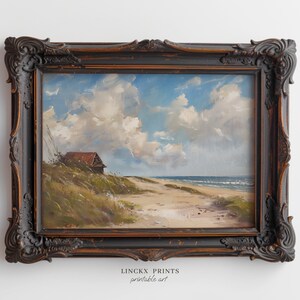 Könnte beinhalten: Ein gerahmtes Gemälde, das eine Küstenlandschaft mit einem kleinen Häuschen an einem Sandstrand zeigt. Der Himmel ist blau mit weißen Wolken und das Meer ist hellblau mit weißen Wellen. Das Gemälde befindet sich in einem dunkelbraunen Rahmen mit verzierten Details.