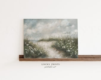 May include: A landscape painting depicts a sandy path leading to the ocean, framed by tall green grass and white wildflowers. The sky is overcast with soft, gray clouds. The artwork is displayed on a wooden shelf, with the text "LINCKX PRINTS printable art" at the bottom.