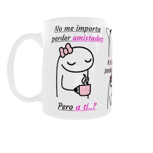 Puede incluir: Una taza de cerámica blanca con un dibujo de líneas negras de un personaje de dibujos animados con un lazo rosa, sosteniendo una taza rosa. El texto dice: No me importa perder amistades Pero a tí..?. El diseño incluye letras negras y rosas en la superficie.