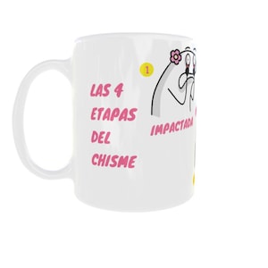 May include: White ceramic mug with a curved handle. The mug features the text "LAS 4 ETAPAS DEL CHISME" in pink, along with a cartoon illustration and the word "IMPACTADA".