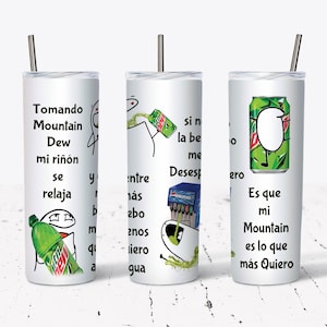 May include: Three white tumblers with a green and white Mountain Dew can design. The tumblers have a straw and text in Spanish that reads "Tomando Mountain Dew mi riñón se relaja", "Entre más bebo menos quiero agua", and "Es que mi Mountain es lo que más quiero".