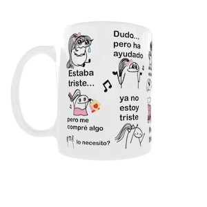 May include: White ceramic mug with a curved handle. The mug features black and pink cartoon illustrations and Spanish text, including "Estaba triste..." and "ya no estoy triste."