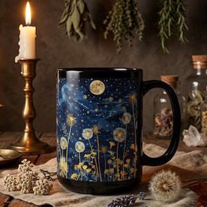 Może przedstawiać: Czarny ceramiczny kubek z motywem nocnego nieba z pełnią księżyca, gwiazdami i ilustracjami dmuchawców. Kubek ma czarny uchwyt i podstawę. Zapalona świeca w złotym świeczniku znajduje się w tle.