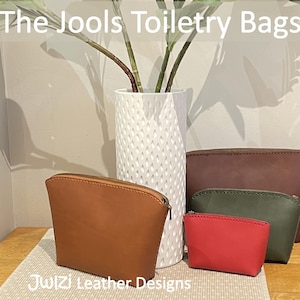 May include: Four leather toiletry bags in different sizes and colors. The bags are arranged in a pyramid shape on a wooden surface. The bags are brown, green, and red. The text "The Jools Toiletry Bags" is at the top of the image. The text "PDF Pattern" is on the right side of the image. The text "Julzi Leather Designs" is at the bottom of the image.