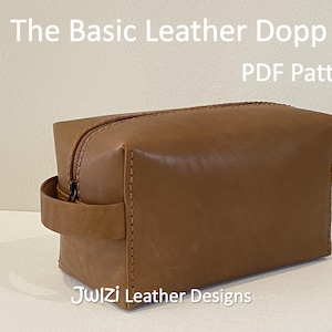 May include: A brown leather Dopp kit with a zipper closure and a handle. The text "The Basic Leather Dopp Kit PDF Pattern" is displayed at the top of the image. The words "JwIZi Leather Designs" are at the bottom.