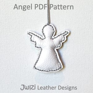 May include: A white leather angel ornament with gray stitching and a hanging string. The text "Angel PDF Pattern" is at the top, and "JwIZi Leather Designs" is at the bottom. The angel has outstretched wings.