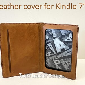 以下が含まれることがあります： 開いた茶色の革製Kindle 7インチカバー。Kindleの画面には白黒のデザインが表示されています。「Leather cover for Kindle 7"」の文字が上部に、「PDF Pattern」の文字が右側にあります。メーカー名は下部にあります。