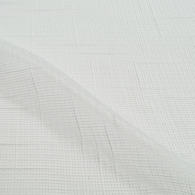 May include: White sheer fabric with a grid pattern. The fabric is folded in half, showing the texture of the material.