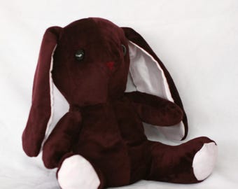 Conejito de peluche con peso en tonos granate y rosa. Hecho con materiales reciclados y con poco desperdicio.