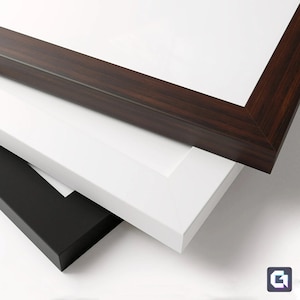 May include: Three picture frames stacked on top of each other. The top frame is dark brown wood, the middle frame is white, and the bottom frame is black.