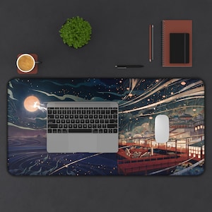 Pode incluir: Um tapete de mesa retangular com uma ilustra&ccedil;&atilde;o detalhada de uma paisagem noturna com lua cheia, edif&iacute;cios e linhas fluidas. Um laptop, um mouse e outros materiais de escrit&oacute;rio est&atilde;o em uma superf&iacute;cie escura.