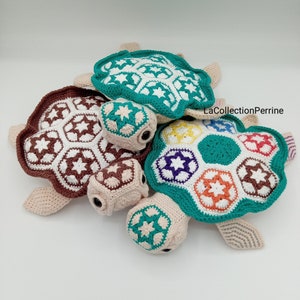 Puede incluir: Tres juguetes de tortuga de crochet con coloridos patrones geométricos en sus caparazones. Las torturas están hechas con hilo beige, marrón, verde, blanco, naranja, morado y amarillo. El texto "LaCollectionPerrine" es visible en el fondo.
