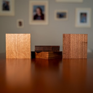 May include: Three wooden coasters, one light brown, one dark brown, and one stack of four coasters in alternating light and dark brown.