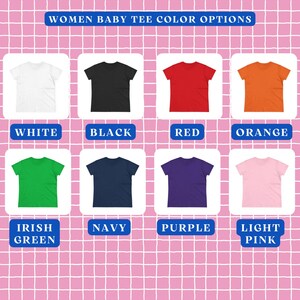 Op de afbeelding: Een raster van acht baby-t-shirts met korte mouwen in wit, zwart, rood, oranje, Iers groen, marineblauw, paars en lichtroze. De tekst bovenaan luidt WOMEN BABY TEE COLOR OPTIONS, met labels onder elk t-shirt die de kleur aangeven.