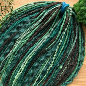 May include: A bundle of synthetic dreadlocks in shades of green and black. The dreadlocks are made of kanekalon hair and are ready to be installed.