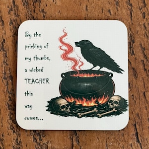 Puede incluir: Posavasos cuadrado con un cuervo negro posado sobre un caldero con llamas y humo. El posavasos tiene el texto "By the pricking of my thumbs, a wicked TEACHER this way comes..."