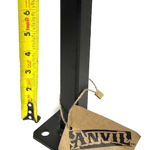 May include: Black metal stand with a square base and a rectangular post. The stand is about 7 inches tall and has a tag that says "ANVIL" on it.