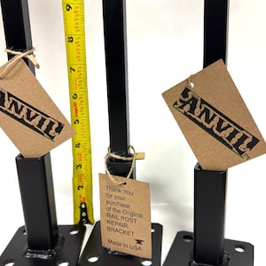 May include: Three black metal rail post repair brackets with a brown paper tag that reads "Thank You for your purchase of the Original RAIL POST REPAIR BRACKET Made in USA".
