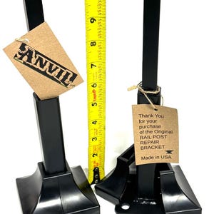 May include: Two black metal rail post repair brackets with a base and a vertical post. The brackets are 7 inches tall and come with 12 silver screws. The text on the brown paper tag reads: "Thank You for your purchase of the Original RAIL POST REPAIR BRACKET Made in USA."