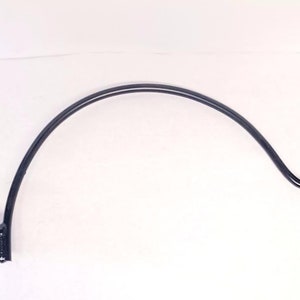 May include: Black metal hook with a curved arm and a hook at the end. The hook is designed to be mounted to a wall or other surface.