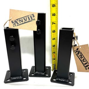 May include: Three black metal table legs with square bases and welded seams. The legs are approximately 6 inches tall. The legs are labeled with the word "ANVIL".