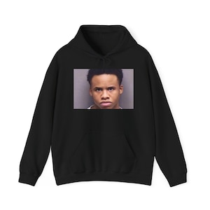 May include: Black hoodie with a photo of a young man's face printed on the front.