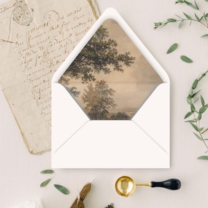 May include: A white envelope with a landscape painting visible inside. The painting features trees and a body of water in muted tones. A vintage letter and decorative elements are also present.