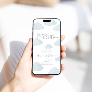 May include: A smartphone displaying a baby shower invitation with a blue watercolour cloud design. The invitation reads "We are on cloud nine" and includes the names "Alison & Gabriel" and the date "Sunday, July 23, 20XX".