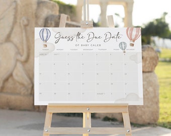 May include: A white calendar with a blue and pink hot air balloon design. The calendar says "Guess the Due Date of Baby Caleb".
