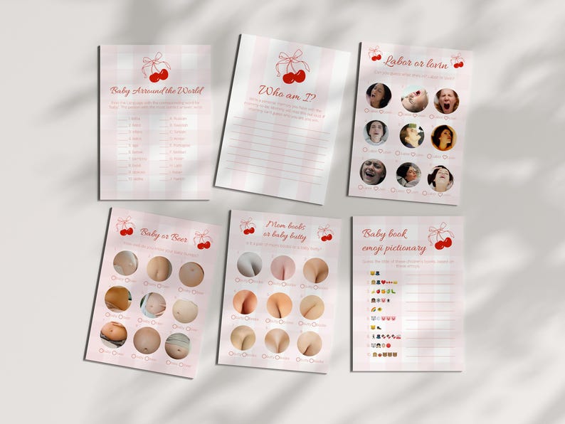 May include: A collection of pink and white baby shower game cards. The cards feature cherry illustrations and titles like "Baby Around the World," "Who am I?" and "Labor or Lovin." The cards have a pink gingham pattern.