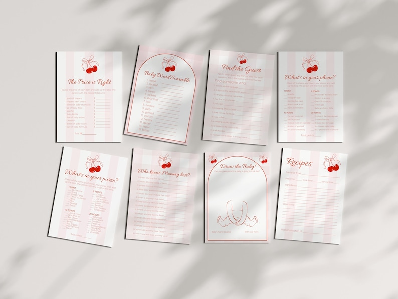 May include: A collection of baby shower game cards with a cherry theme. The cards feature pink and white striped backgrounds and red cherry illustrations. Games include "The Price is Right," "Baby Word Scramble," and "Draw the Baby."