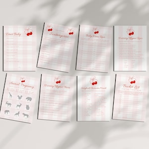 May include: A collection of eight baby shower game sheets. Each sheet features a pink and white gingham or striped pattern with red cherry illustrations. Games include "Dear Baby," "Scattergories," and "Baby Name Race."