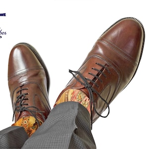 May include: Brown leather dress shoes with black laces, paired with patterned socks and gray trousers. The image includes the "Maritime Tribes" logo and a decorative art print.