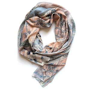 May include: A light pink and blue silk scarf with a vintage map print. The map features streets and landmarks in a city.