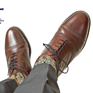 May include: Brown leather dress shoes with black laces, paired with patterned socks and gray trousers. The image includes the text "Maritime Tribes LOVE your place" and a decorative sock with a floral design.