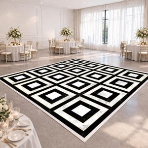 May include: A black and white geometric patterned dance floor with a gold border. The floor is in a large, well-lit room with round tables, chairs, and floral centerpieces. The room has white walls and large windows with sheer curtains.