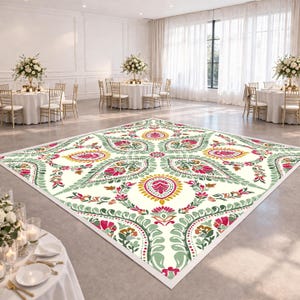May include: A large, square dance floor with a cream-colored background and a colorful floral pattern in shades of pink, green, yellow, and brown. The dance floor is set up in a large event space with round tables and chairs.