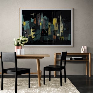 May include: Abstract art print in a light wood frame, depicting a cityscape in dark teal, yellow, and brown hues. The artwork hangs above a wooden dining table with two black chairs. A rug, a vase of flowers, and a side table complete the scene.