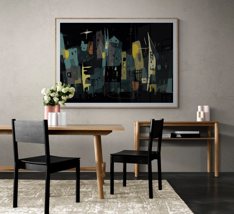 May include: Abstract art print in a light wood frame, depicting a cityscape in dark teal, yellow, and brown hues. The artwork hangs above a wooden dining table with two black chairs. A rug, a vase of flowers, and a side table complete the scene.