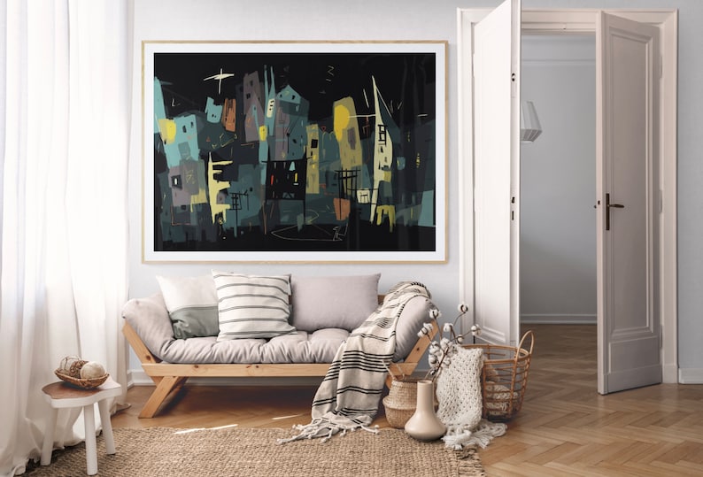 May include: Abstract art print featuring a cityscape in shades of teal, yellow, and gray against a black background. The artwork is framed in a natural wood frame and hangs above a wooden sofa with pillows and a blanket. The room has a neutral color palette.