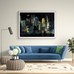 May include: Abstract art print featuring a cityscape in shades of teal, yellow, and brown against a black background. The artwork is framed and hangs above a blue sofa with pillows. A floor lamp and potted plant complete the room.