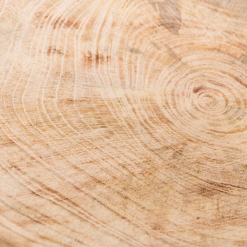 May include: Close-up of a light brown wood grain pattern with concentric circles. The wood has a natural, warm tone.