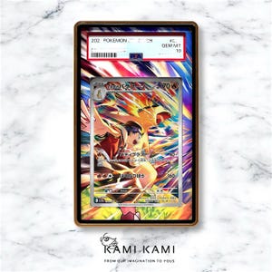 K&ouml;nnte beinhalten: Eine gerahmte Pok&eacute;mon-Sammelkarte mit einer farbenfrohen Illustration eines Charakters in Orange- und Rott&ouml;nen. Die Karte ist bewertet und in einem Schutzhalter mit dem Text "GEM MT 10" eingeschlossen. Der Rahmen hat einen goldenen Rand.